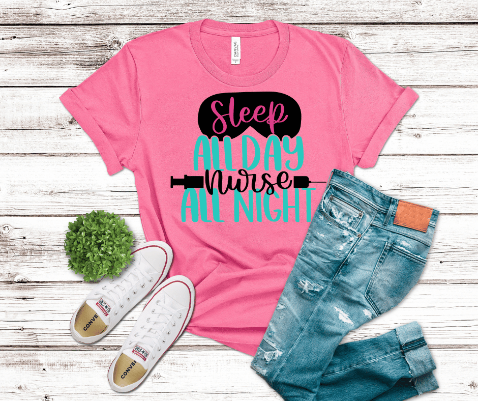 “Sleep All Day Nurse All Night” nurse shirt with sleep mask and syringe graphics on pink background.
