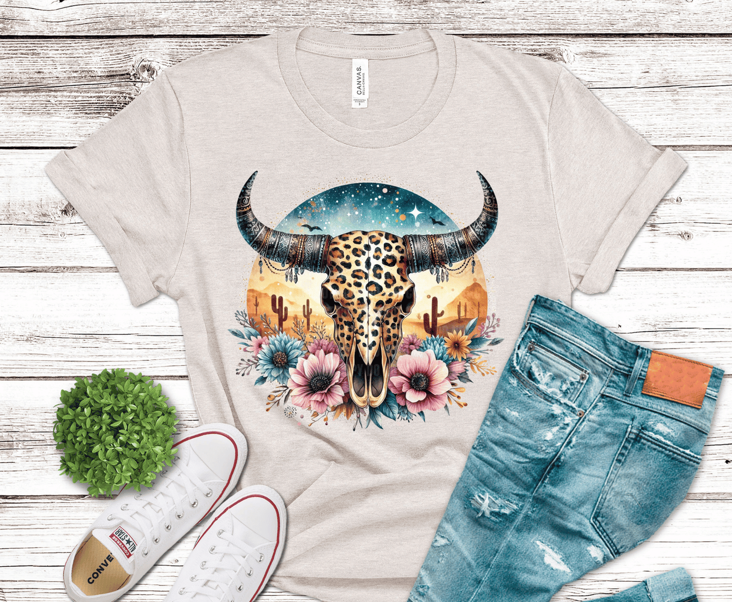 DTF transfer featuring a leopard print steer skull with western horns, desert cacti, florals, and a boho sunset background.