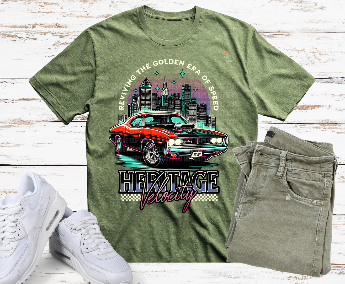 Green t-shirt with a graphic of a red car and cityscape, paired with white sneakers and jeans on a wooden surface.