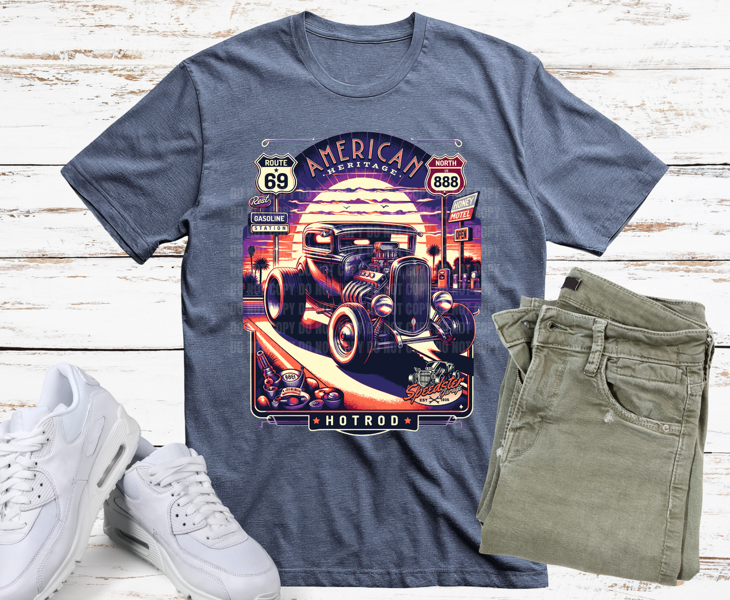 Gray t-shirt with hot rod graphic design on a wooden surface with white sneakers and green jeans.