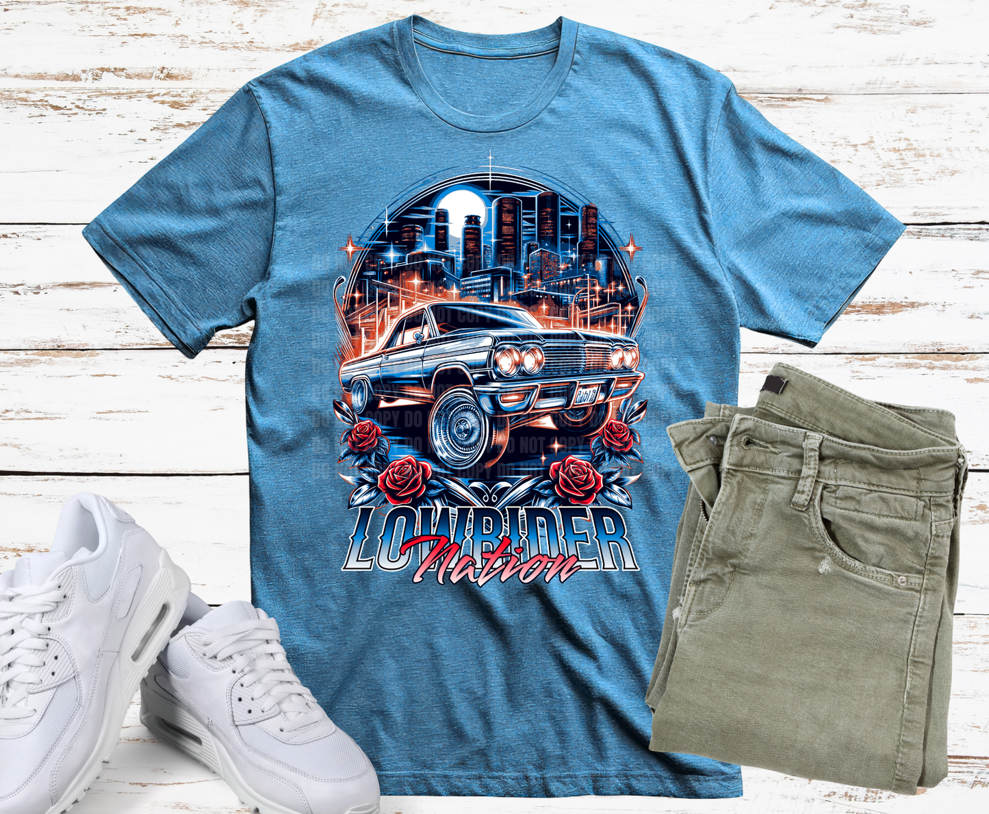 Blue t-shirt with car graphic and 'Lowrider Nation' text, paired with white sneakers and green shorts on a wooden surface.
