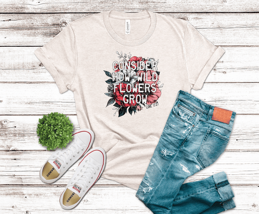 DTF transfer featuring bold white text reading “Consider How Wild Flowers Grow” over red and pink wildflowers with dark leaves on a black background.