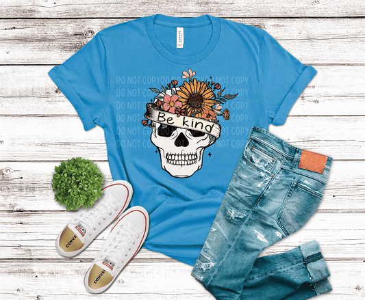 Skull with floral crown and banner saying be kind combining edgy and positive design elements