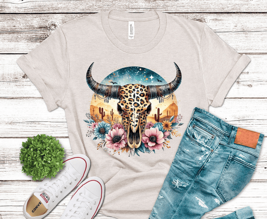 DTF transfer featuring a leopard print steer skull with western horns, desert cacti, florals, and a boho sunset background.