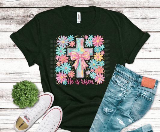 Pastel floral He Is Risen Easter cross design with pink coquette bow, colorful spring flowers and gold accents for Christian Easter shirt printing