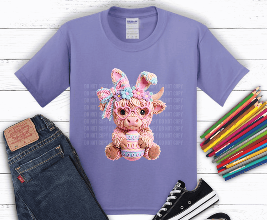 Pastel coquette highland cow wearing bunny ears and heart glasses holding Easter egg for cute spring Easter shirt design