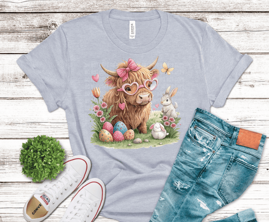 Highland cow wearing pink bow and heart sunglasses surrounded by pastel Easter eggs and bunnies in soft watercolor spring style