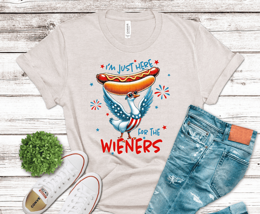 Funny patriotic goose holding a hotdog with text I'm Just Here For The Wieners and fireworks.