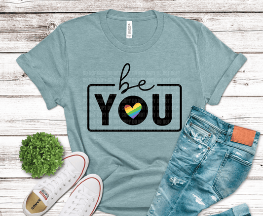 Be You text with rainbow heart inside the word you.