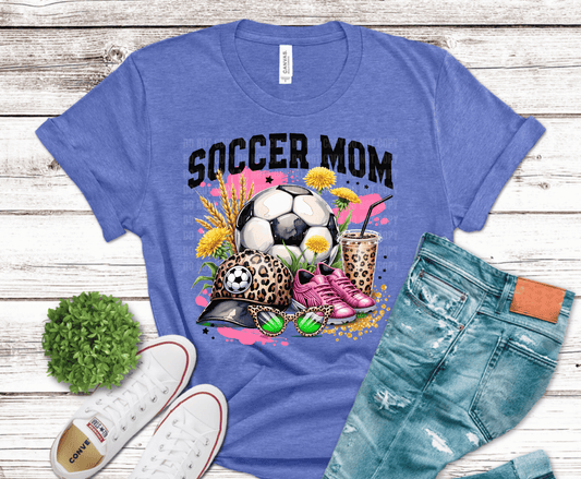 Trendy soccer mom graphic design with leopard print hat, soccer ball, pink cleats, iced coffee, and floral accents for stylish sports moms